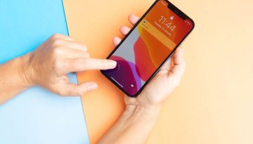 La persona usa il suo iPhone per firmare i documenti.