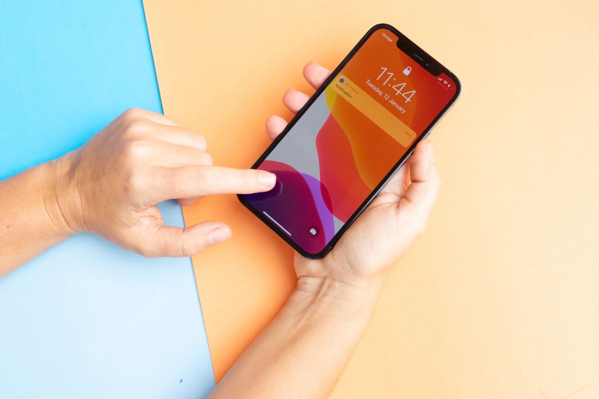 La persona usa il suo iPhone per firmare i documenti.