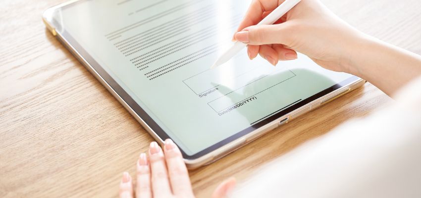A professional signs a contract online.