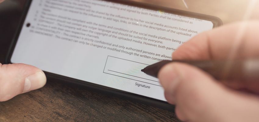يوقع الشخص على اتفاقية رقمية باستخدام توقيع إلكتروني.
