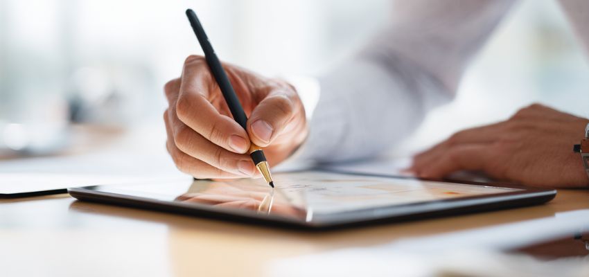 Person using a contract tool to sign a digital agreement on a tablet with an e-signature
