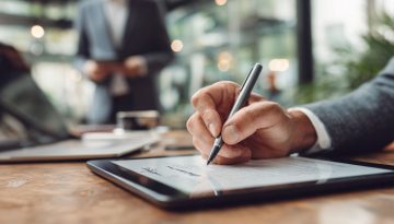 Primo piano di un uomo che firma un documento digitale su un tablet come firmatario autorizzato.