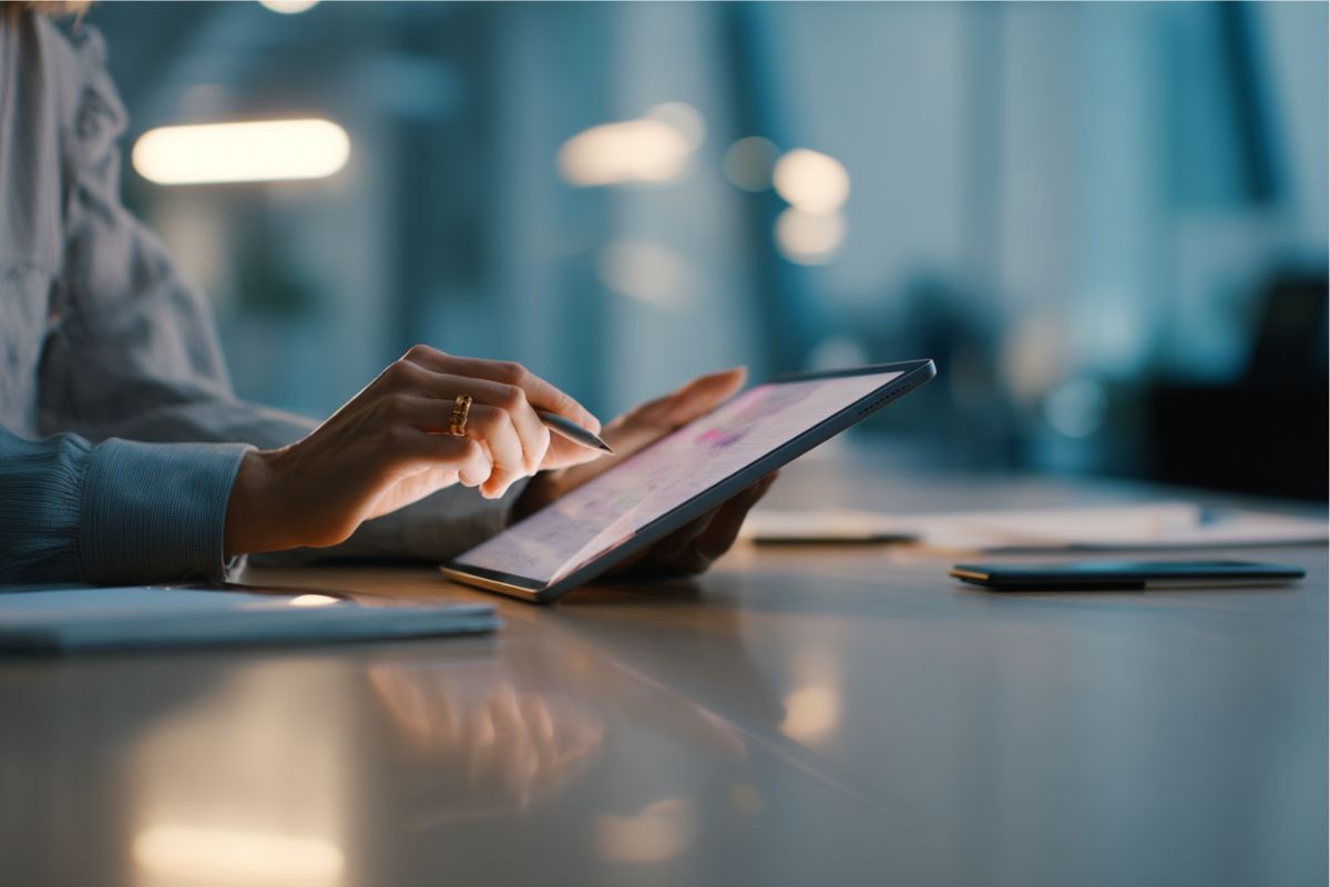 Close-up of hands using stylus to review contract strategies on a tablet device
