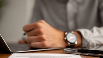 Close-up of professional reviewing paperwork showing types of contract